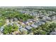 Birds-eye shot of closely spaced houses amid lush trees in a well-established neighborhood, highlighting green space and rooftops at 7508 S Mascotte St, Tampa, FL 33616