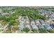 High-angle aerial shot of a residential area showing a mix of houses, green trees, and the coastal landscape in the distance at 7508 S Mascotte St, Tampa, FL 33616