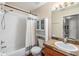 Bright bathroom with a shower-tub combo, white tile, and storage cabinet at 7508 S Mascotte St, Tampa, FL 33616