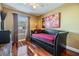 Comfortable bedroom featuring wood floors, a futon, and a window at 7508 S Mascotte St, Tampa, FL 33616