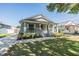 Charming single-story home with a welcoming front porch, a neatly manicured lawn, and a vibrant red front door at 7508 S Mascotte St, Tampa, FL 33616