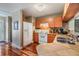 Cozy kitchen featuring wood cabinets, white appliances, and hardwood floors at 7508 S Mascotte St, Tampa, FL 33616