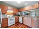 Kitchen area featuring wood cabinets, tile backsplash, hardwood floors, and a breakfast bar at 7508 S Mascotte St, Tampa, FL 33616