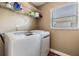 Efficient laundry area with modern washer and dryer, shelving, and a window at 7508 S Mascotte St, Tampa, FL 33616
