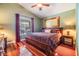 Cozy bedroom with a queen-size bed, hardwood floors, and a ceiling fan at 7508 S Mascotte St, Tampa, FL 33616
