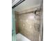 Shower features beautiful tiling, a shower caddy, a modern shower head, and glass doors at 880 Mandalay Ave # S511, Clearwater Beach, FL 33767