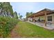 Landscaped backyard area with a covered patio, shed, and privacy hedge at 8805 Van Fleet Rd, Riverview, FL 33578