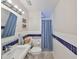 Well-lit bathroom featuring a single sink vanity, toilet, and accessible shower behind a curtain at 8805 Van Fleet Rd, Riverview, FL 33578
