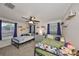 Cozy bedroom featuring two twin beds, a ceiling fan, and decoratively adorned walls with shelving at 8805 Van Fleet Rd, Riverview, FL 33578