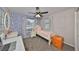 Well-lit bedroom featuring a single bed, an accent wall with polka dots, and a comfortable workspace at 8805 Van Fleet Rd, Riverview, FL 33578