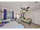 Cozy bedroom featuring two twin beds, a ceiling fan, and decoratively adorned walls with shelving at 8805 Van Fleet Rd, Riverview, FL 33578