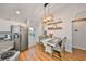 Bright dining area features wood floors, modern light fixture, and adjacent stainless steel appliances at 8805 Van Fleet Rd, Riverview, FL 33578