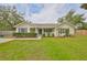 Charming home with a manicured lawn, trimmed hedges, black shutters, and inviting front porch at 8805 Van Fleet Rd, Riverview, FL 33578