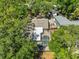 Aerial view of a private backyard with a screened pool, nestled among mature trees and lush landscaping at 940 Woodland Dr, Palm Harbor, FL 34683