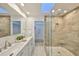 Bright bathroom featuring double vanity, marble countertop and large, glass enclosed shower at 940 Woodland Dr, Palm Harbor, FL 34683
