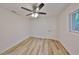 Cozy bedroom showcases wood-look flooring, ceiling fan with light, and a window at 940 Woodland Dr, Palm Harbor, FL 34683