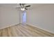 Bright bedroom features wood-look flooring, ceiling fan with light, and neutral walls at 940 Woodland Dr, Palm Harbor, FL 34683