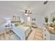 Airy main bedroom features ceiling fan, white comforter, and light-colored wood flooring at 940 Woodland Dr, Palm Harbor, FL 34683