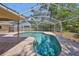 Pool with screened enclosure with clear blue water and brick paver patio at 940 Woodland Dr, Palm Harbor, FL 34683