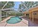 Beautiful pool surrounded by screened enclosure and brick patio at 940 Woodland Dr, Palm Harbor, FL 34683