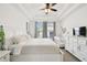 Bright bedroom with white furniture, ceiling fan, tray ceiling, and natural light creates a peaceful and inviting space at 10011 Parley Dr, Tampa, FL 33626