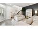 Bright, open living room with a large mirror, hardwood floors, and a modern staircase leading to the second floor at 10011 Parley Dr, Tampa, FL 33626