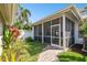 Screened-in patio with a ceiling fan surrounded by greenery and a brick path at 10011 Parley Dr, Tampa, FL 33626