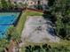 Overhead shot of a vacant sand volleyball court next to tennis courts and upscale neighborhood at 10011 Parley Dr, Tampa, FL 33626