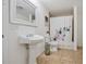 Traditional bathroom with floral shower curtain, pedestal sink and tiled floor at 105 W Columbus Dr, Tampa, FL 33602