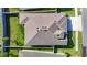 Aerial view of a home's roof and landscaping with green grass and surrounding white fence at 10978 Laxer Cay Loop, San Antonio, FL 33576