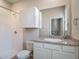 This bathroom offers a tiled shower, a sink with a mirror, and a toilet at 10978 Laxer Cay Loop, San Antonio, FL 33576