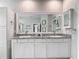Bright bathroom featuring double sinks, a large mirror, and a neutral color palette at 10978 Laxer Cay Loop, San Antonio, FL 33576