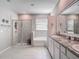 A bright bathroom featuring double sinks, a soaking tub, and a glass enclosed shower at 10978 Laxer Cay Loop, San Antonio, FL 33576