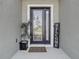 Inviting front entrance featuring a decorative glass door, welcome mat, and potted plant at 10978 Laxer Cay Loop, San Antonio, FL 33576