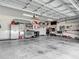 Spacious garage with high ceilings, storage cabinets, and a variety of tools and equipment at 10978 Laxer Cay Loop, San Antonio, FL 33576