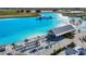 An overhead shot displays Mirada Lagoon, with clear blue waters, sandy beach, and waterside structures at 10978 Laxer Cay Loop, San Antonio, FL 33576