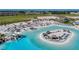 A lagoon view shows a sandy beach area, clear waters with water slides, lounge chairs, and tropical trees at 10978 Laxer Cay Loop, San Antonio, FL 33576