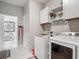 Clean laundry room with white cabinets, decorative signs, and a view into another room at 10978 Laxer Cay Loop, San Antonio, FL 33576