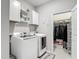 Bright laundry room with white appliances, shelves and storage, and an open door to a closet at 10978 Laxer Cay Loop, San Antonio, FL 33576