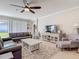 Open living room with comfortable sofas, ceiling fan, and entertainment center, great for relaxation at 10978 Laxer Cay Loop, San Antonio, FL 33576