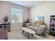 This living room has a comfortable sofa, storage shelves, and plenty of natural light from the window at 10978 Laxer Cay Loop, San Antonio, FL 33576