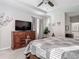 Well-lit main bedroom featuring stylish furnishings, wood dresser, and decorative art at 10978 Laxer Cay Loop, San Antonio, FL 33576