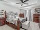 Bright main bedroom featuring tray ceilings, a ceiling fan, and stylish furnishings at 10978 Laxer Cay Loop, San Antonio, FL 33576