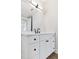 Bathroom vanity with white cabinets, black hardware, and modern fixtures under a large mirror at 11 29Th N St, St Petersburg, FL 33713