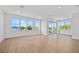Expansive living area featuring wood-look floors and large windows with access to an outdoor balcony at 11 29Th N St, St Petersburg, FL 33713