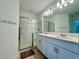 Bathroom with dual sinks, white cabinets, and glass-enclosed shower at 11268 Fieldstone Dr, Palmetto, FL 34221