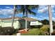 Charming single-story home with a well-manicured lawn and lush landscaping, including palm trees at 11468 Captiva Kay Dr, Riverview, FL 33569