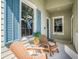 Inviting front porch with cozy chairs, blue shutters, and decorative wreath at 13539 Circa Crossing Dr, Lithia, FL 33547