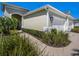 Quaint home with a light green exterior, arched entryway and walkway with well-maintained landscaping at 13539 Circa Crossing Dr, Lithia, FL 33547