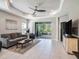 Bright living room with a ceiling fan, tiled floors, and sliding doors to the outdoor space at 13539 Circa Crossing Dr, Lithia, FL 33547